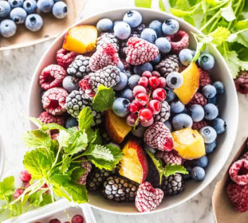 Frozen fruits blueberries blackberry raspberry red currant peach and herbs melissa.